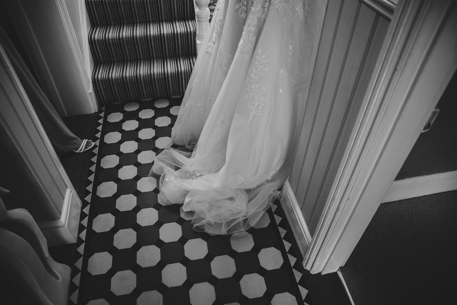 Wedding dress on art deco tiled floor at brides home