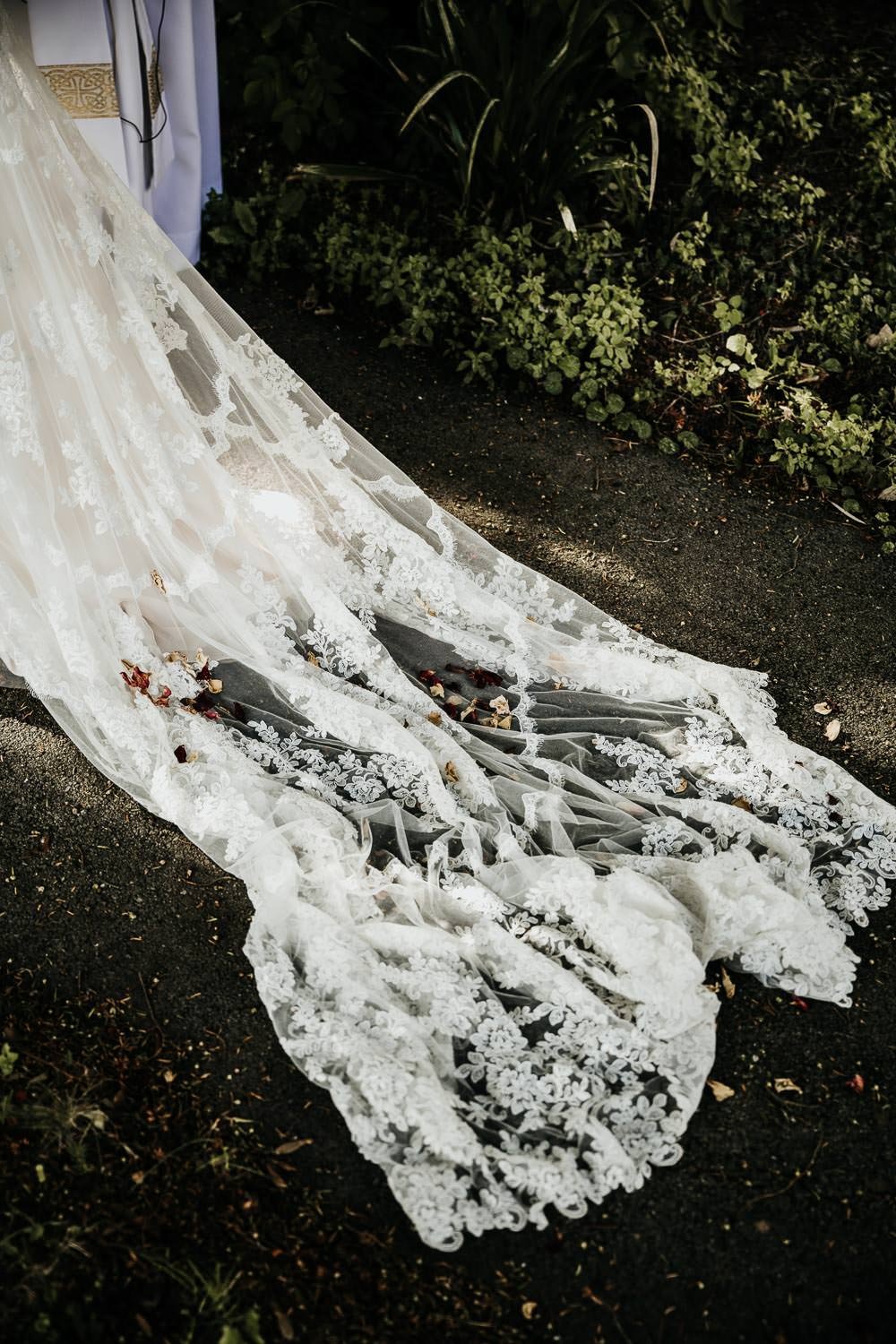 Vintage lace wedding train on church pathway with floral detail