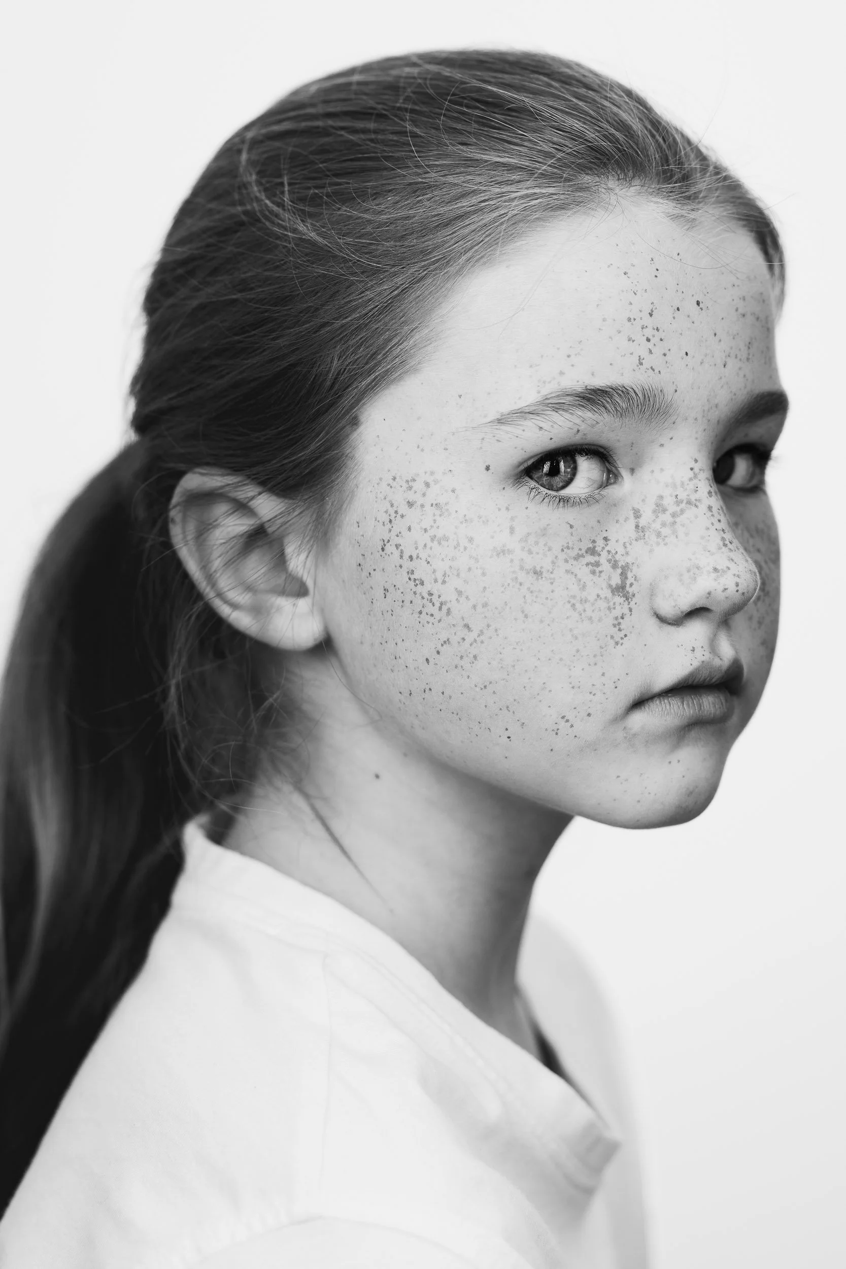 Fine art black and white angled studio portrait of a girl, child portrait photographer Hertfordshire
