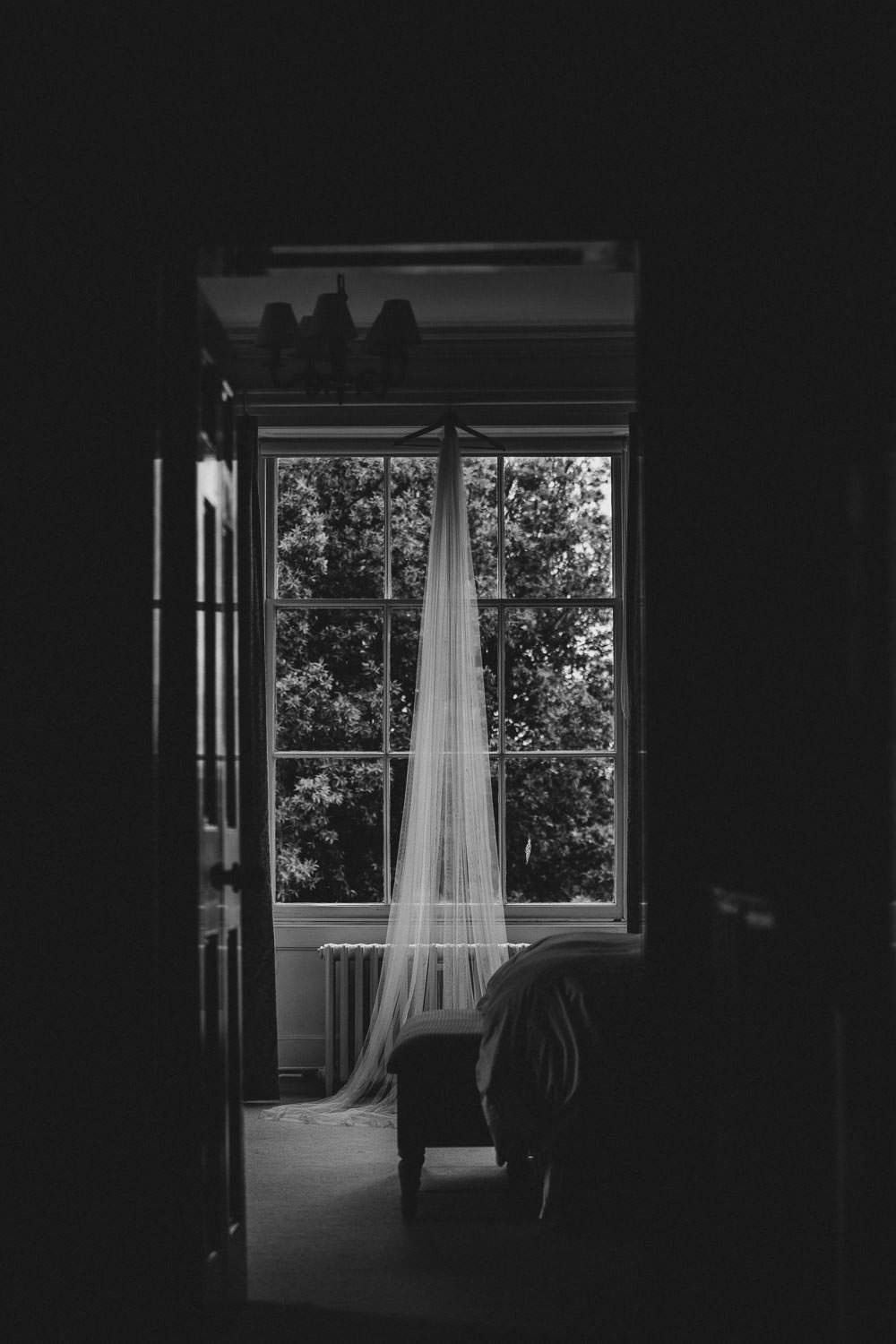 Lace veil hanging from curtain rail down a corridor