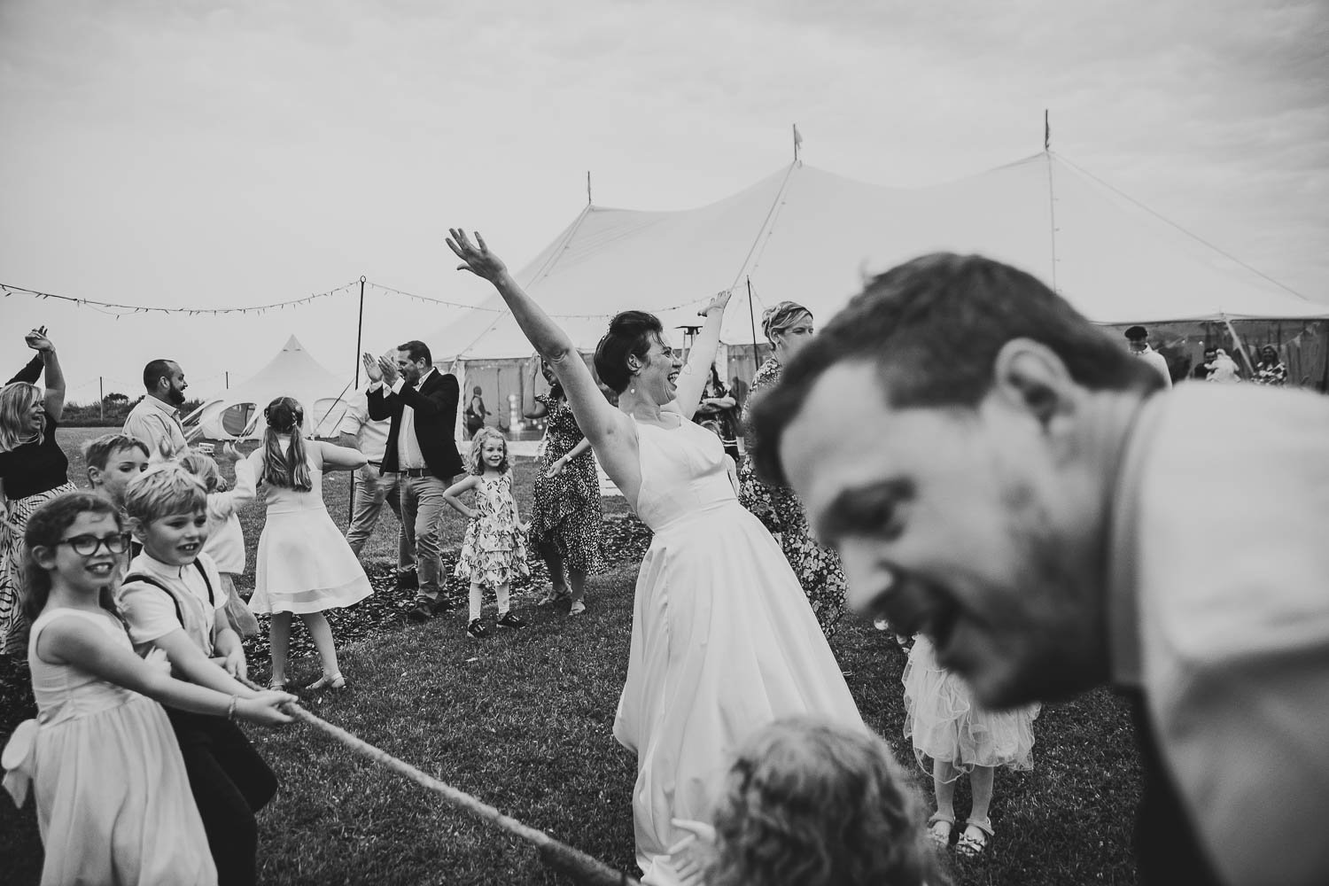 Bride cheering after winning tug of war at Hardwick Moat Weddings