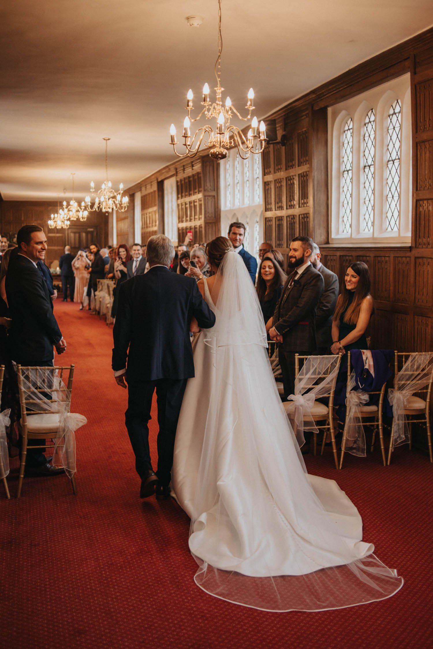 Bride and father walking down aisle at Gosfield Hall in Essex