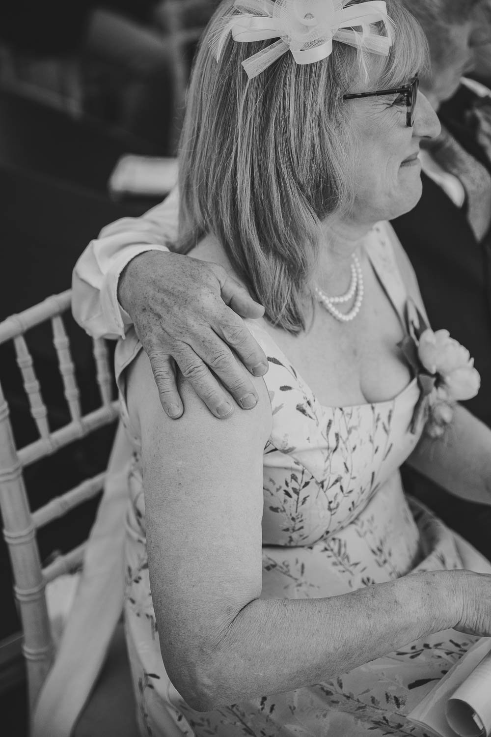 Guest with arm around wife watching the wedding ceremony