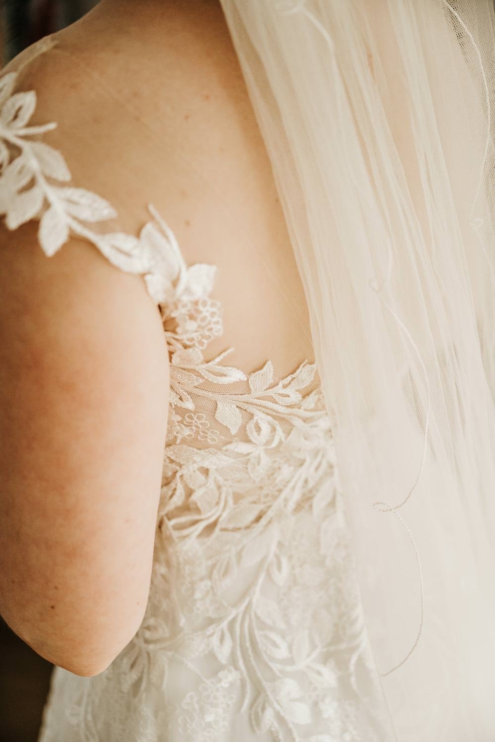 Bride's shoulder with floral lace wedding dress strap