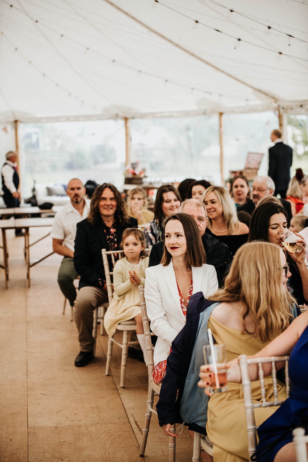  Wedding guests sit in the marquee waiting for the bride to arrive. 