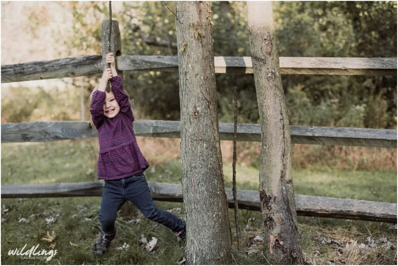 A toddler hangs from a monkey vine at Beechwood Nature Reserve in Pittsburgh