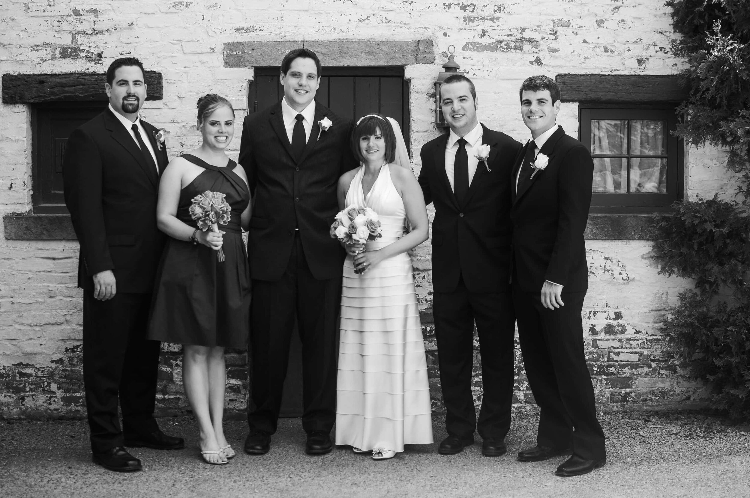 Small wedding party that includes the bride and groom with four other adults, taken in front of the Hyeholde in Coraopolis at their microwedding