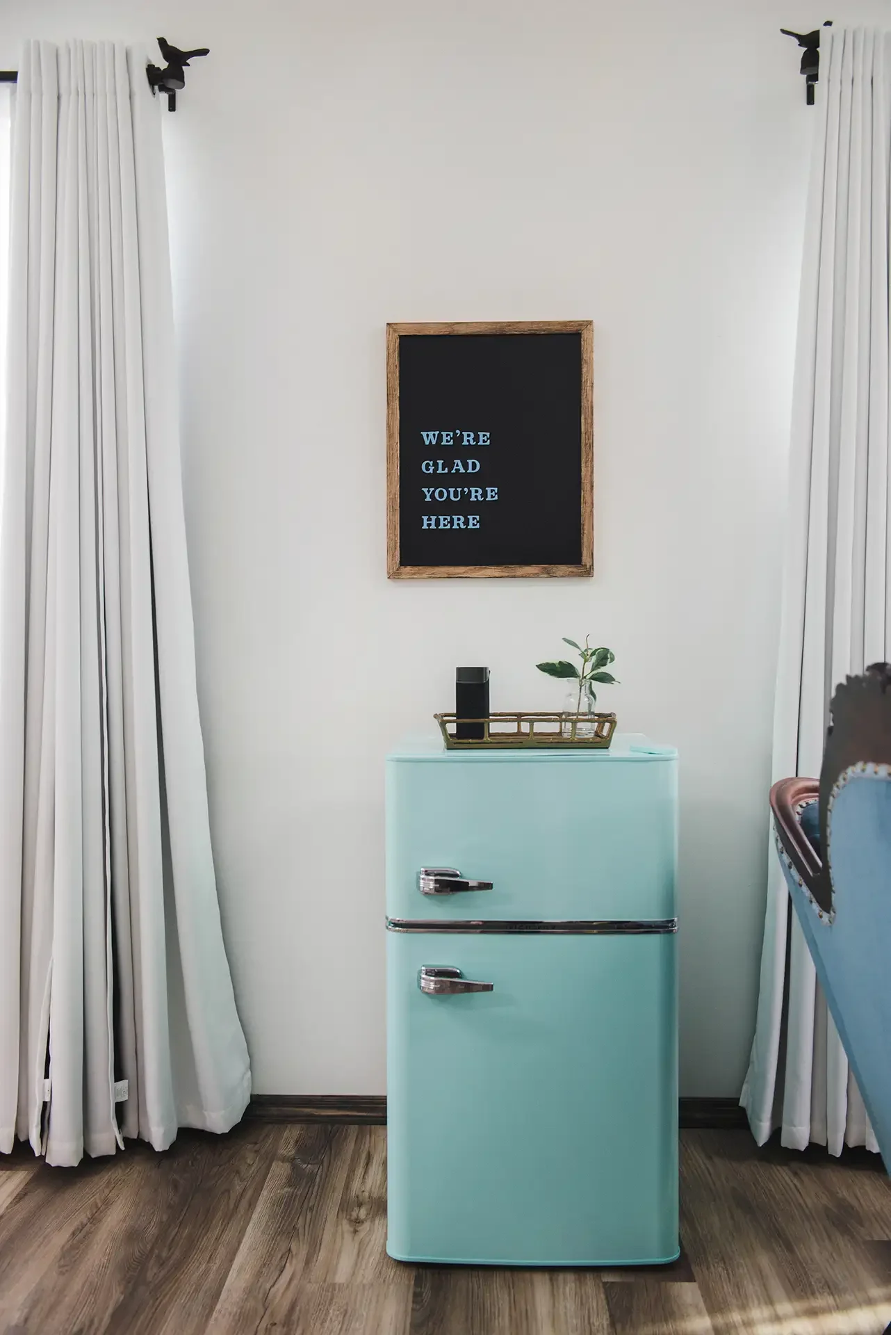 the mint fridge and the sign with magnet letters that says we're glad you're here