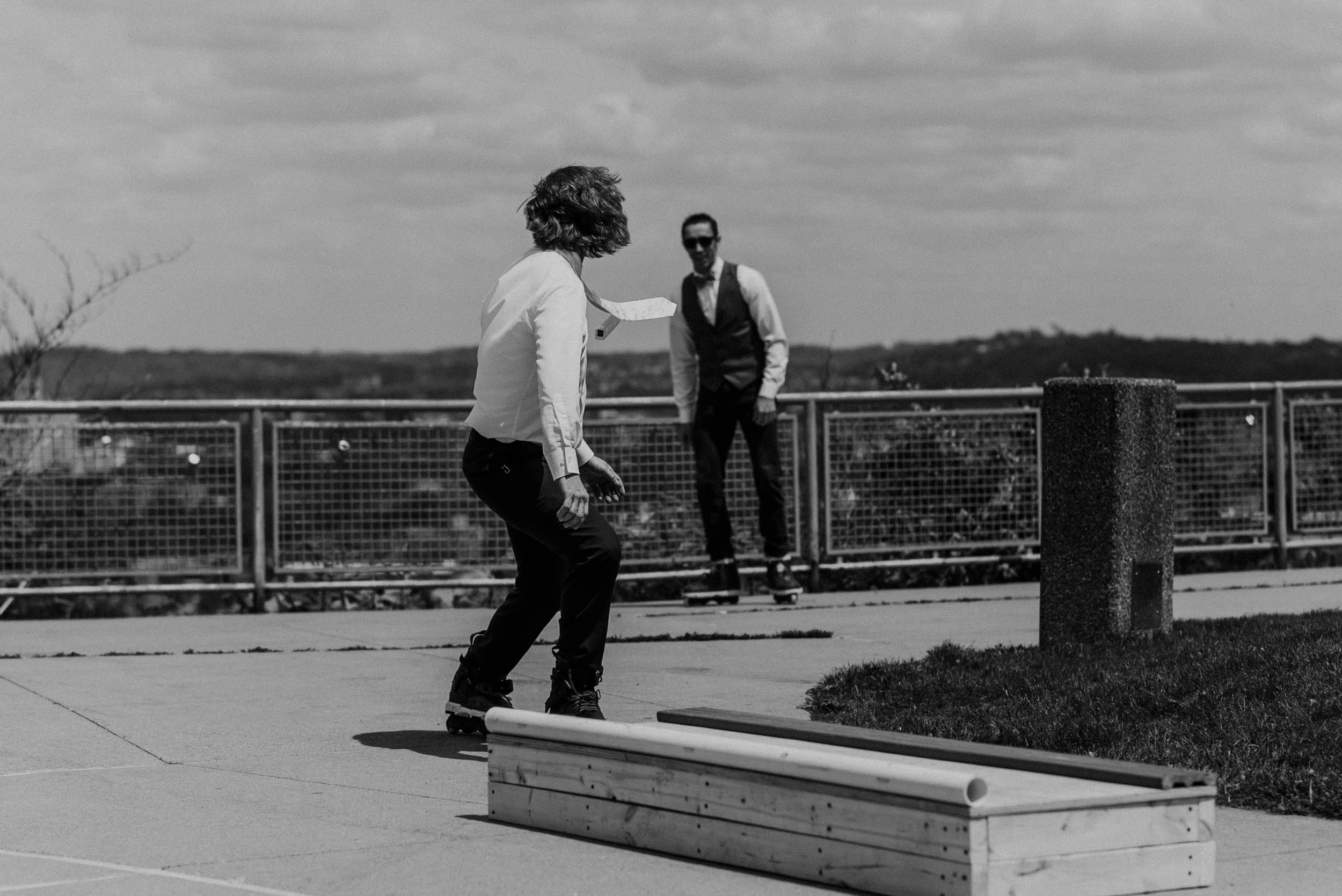 Groom and groomsmen in wedding attire rollerblade at a West End Overlook elopement