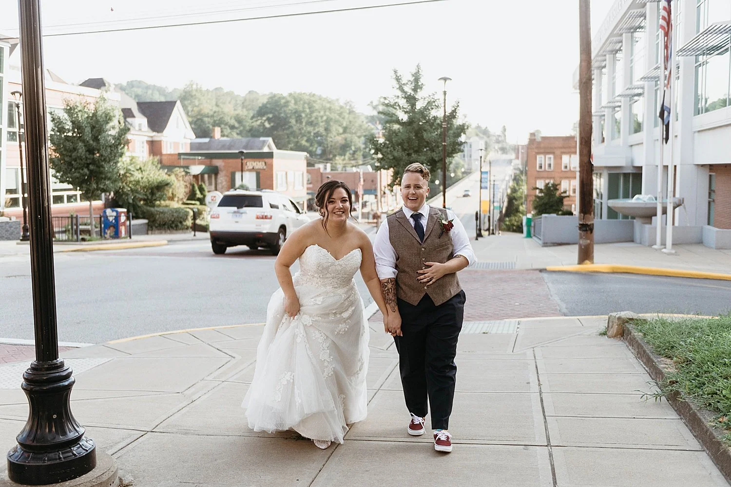 Bride and groom walking toward camera and smiling on the street in morgantown, wv