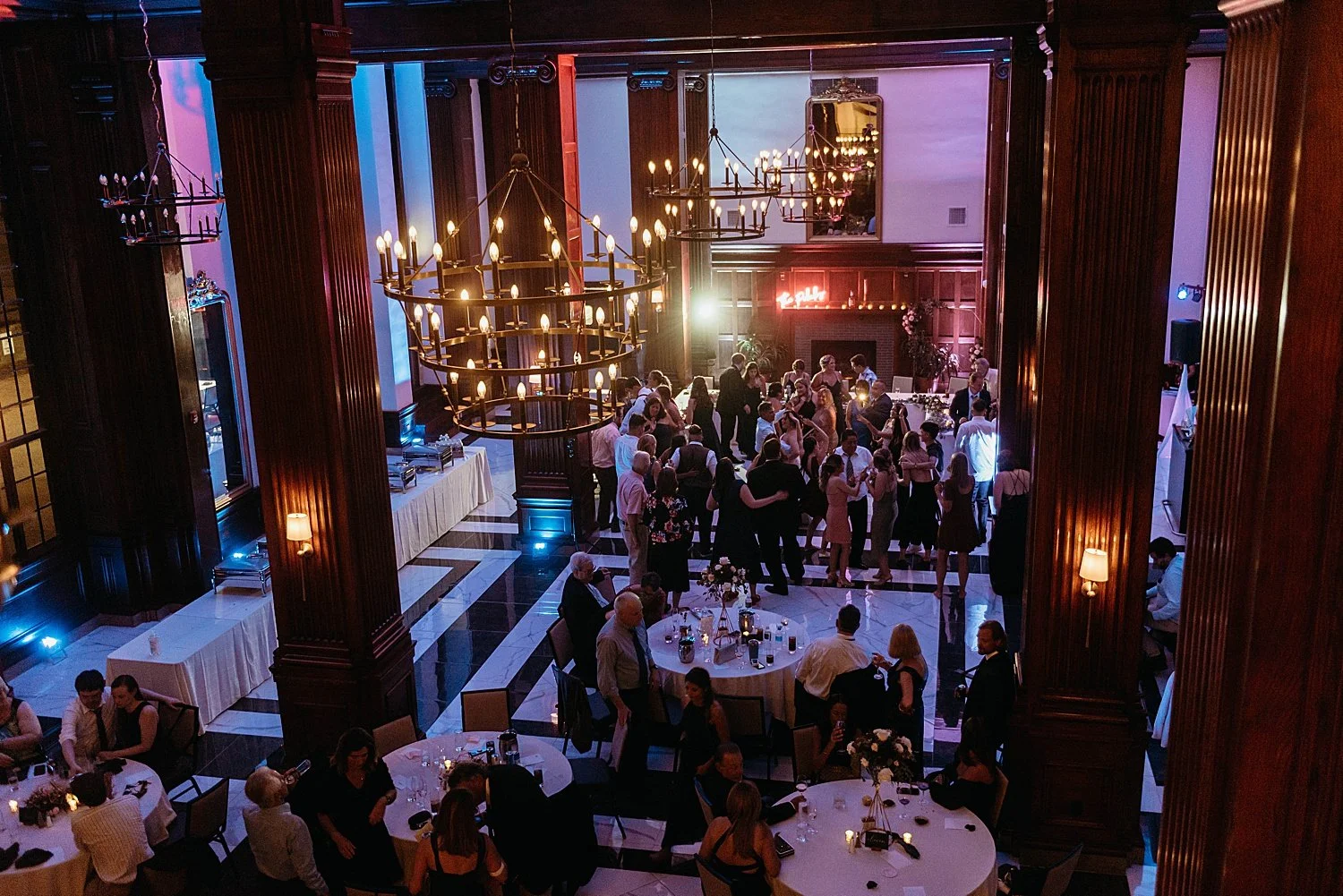 wide shot of the whole dance floor at hotel morgan, the lighting is purple and blue, a huge chandelier is visible