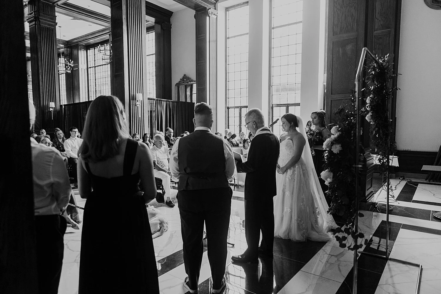 black and white photo from behind the wedding party
