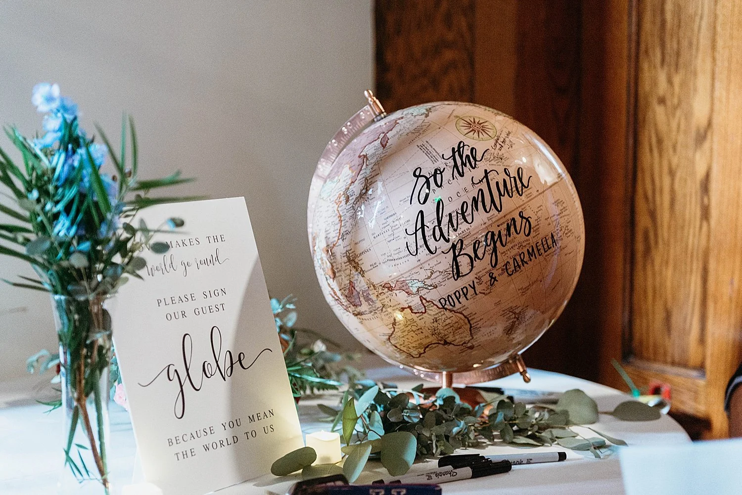 A globe that reads "so the adventure begins" and a sign asking guests to sign it