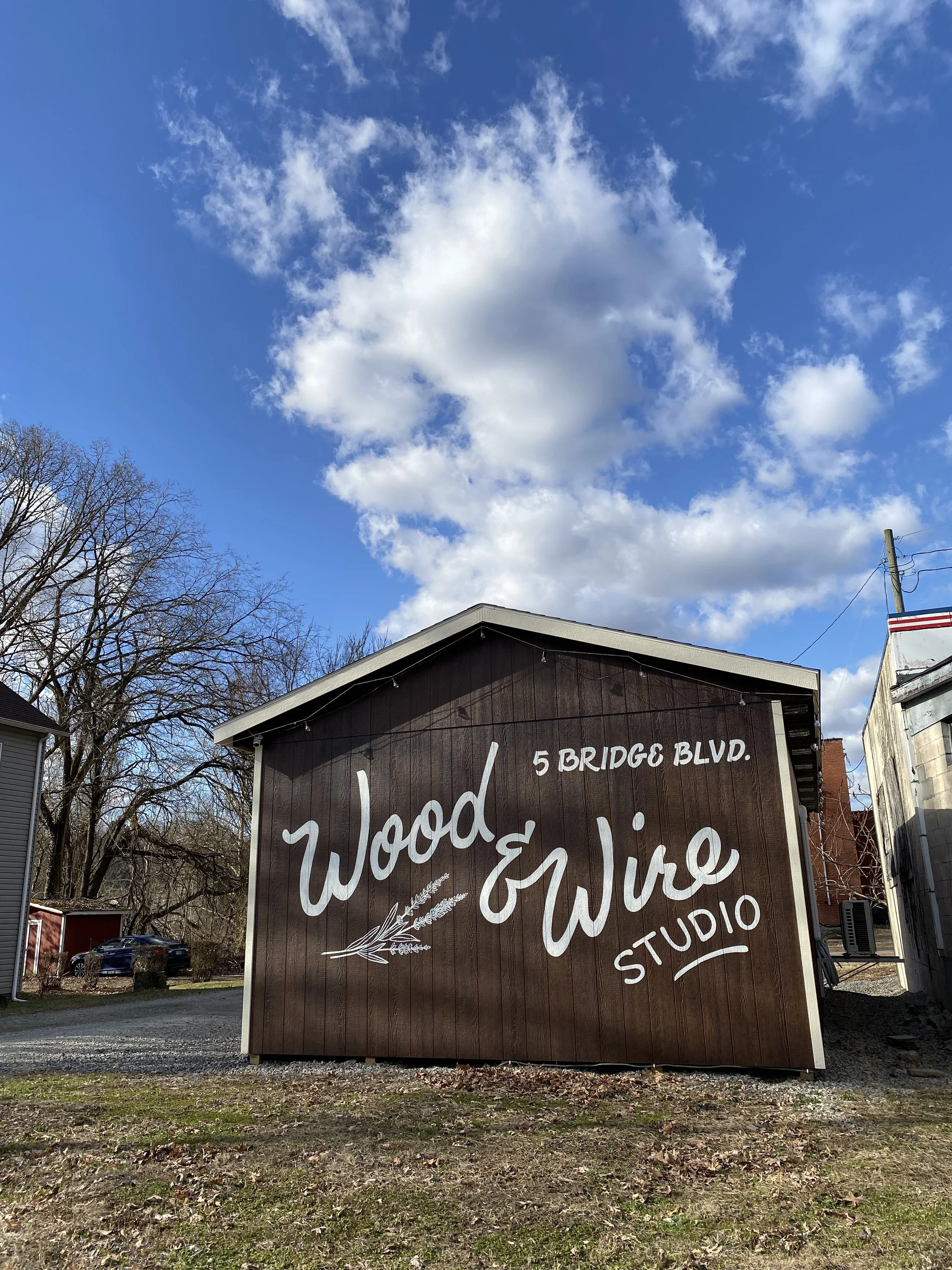 exterior photo of wood and wire studio, a photography studio in west brownsville pa. the image shows the hand painted sign on the side of the brown building.