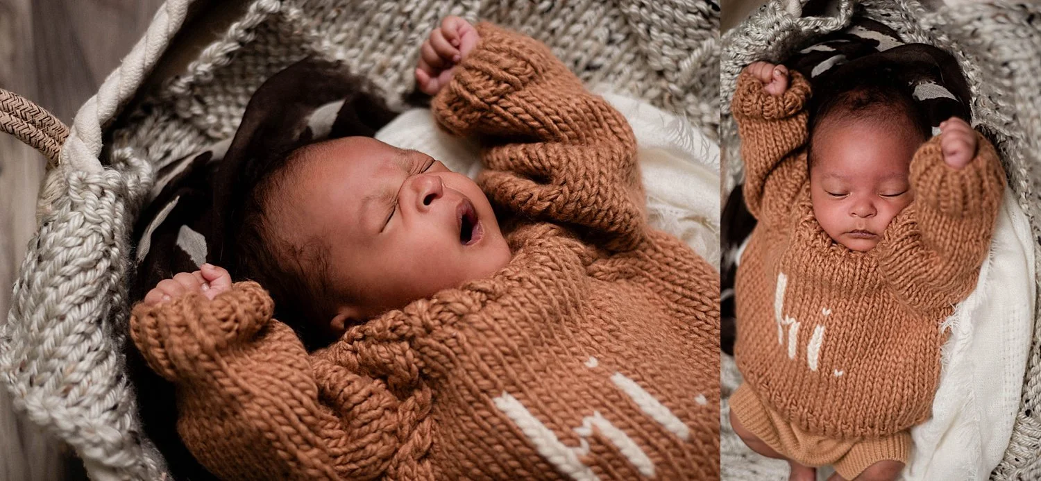 newborn yarns and stretches, she is wearing a brown knit sweater that says 'hi' and is resting in a Moses basked filled with cream and brown fabrics