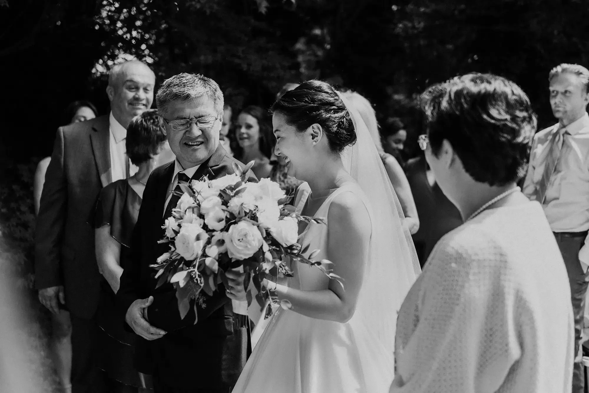 Bride and her father exchange a special inside joke as he walks her down the aisle, black and white, outdoor ceremony at the hyeholde