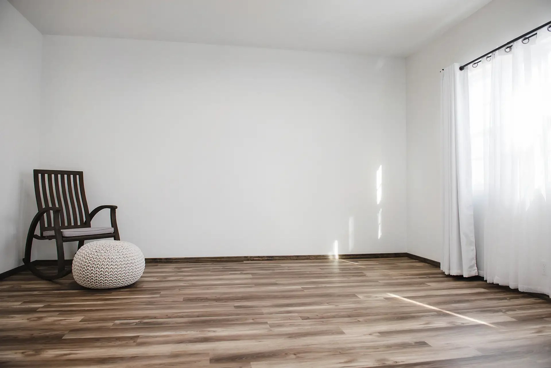 interior of the studio, shows a large white space with sunlight and a rocking chair