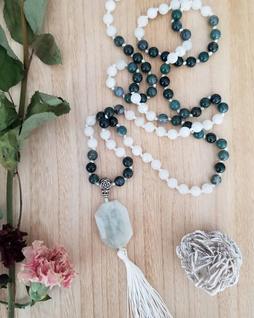 A #CustomOrder for a #Moonstone and #MossAgate #mala. So that the #NewBeginnings upon you can be met with strength, grace, and ease.

#GuruBead: sterling silver flower
#FocalStone: moonstone

#JapaMeditation #108stones #MetaphysicalJuju #Mindfulness 