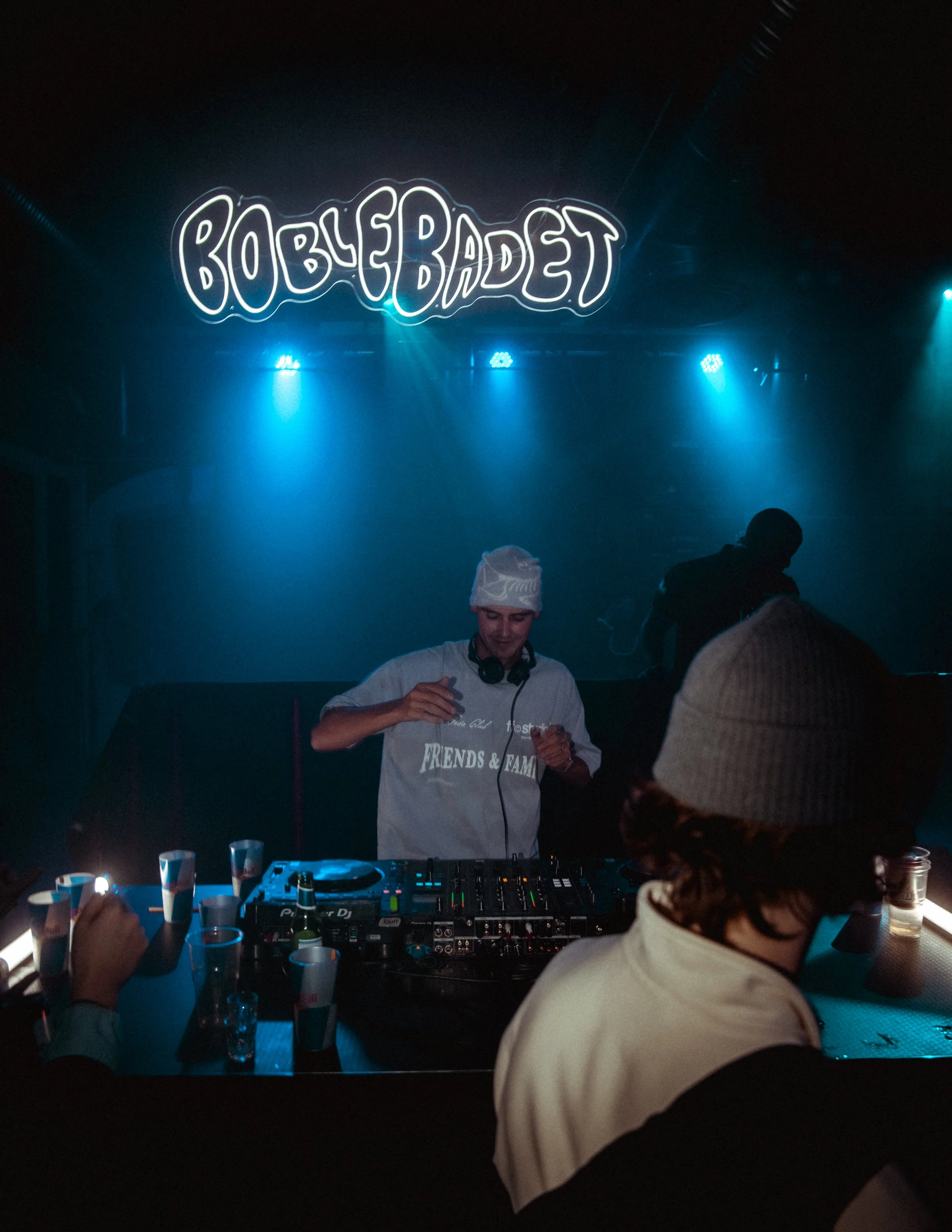 Bilde av Dj-en på Oslo Street Food med neon skilt av "Boblebadet" - nattklubb