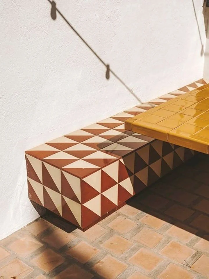 Outdoor Seating [ ] A dynamic pattern and contrast draw the eye into this floating outdoor bench seat, and we love the fun mustard-tiled table top and those terracotta floor tiles. Architecture and Design by @isabellopezvilaltaasociados⁣ + Photo Cred