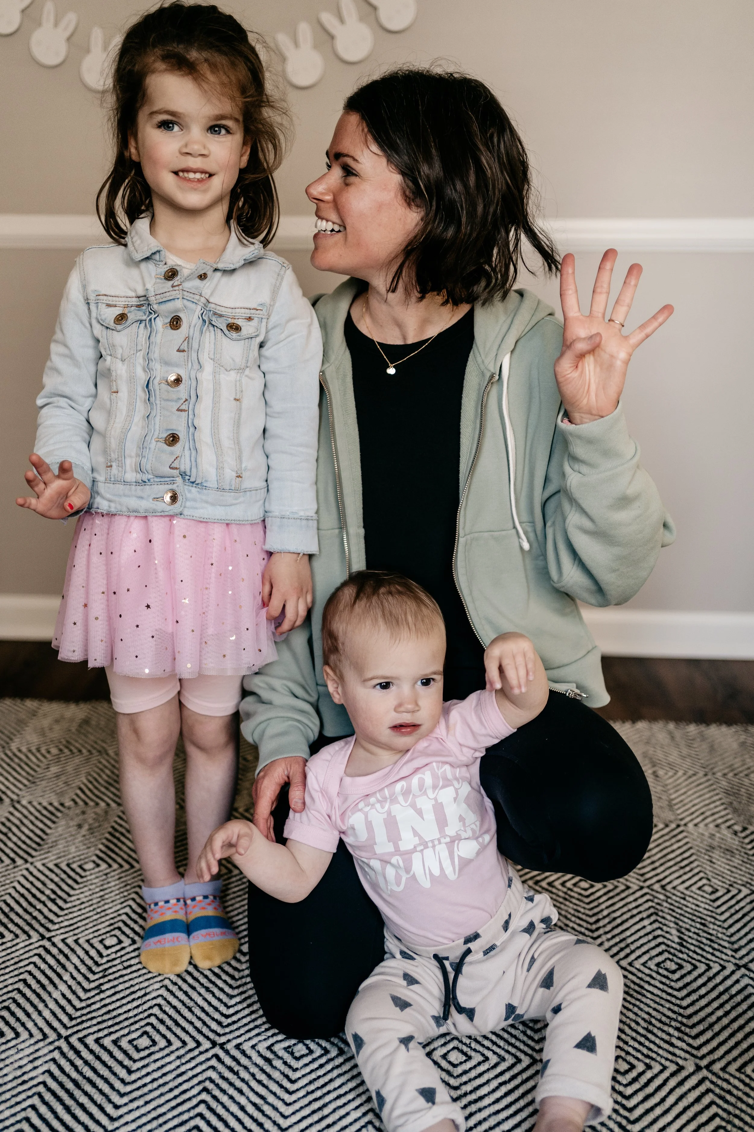 mother with young daughter and son, holding up four fingers for finishing fourth chemo treatment