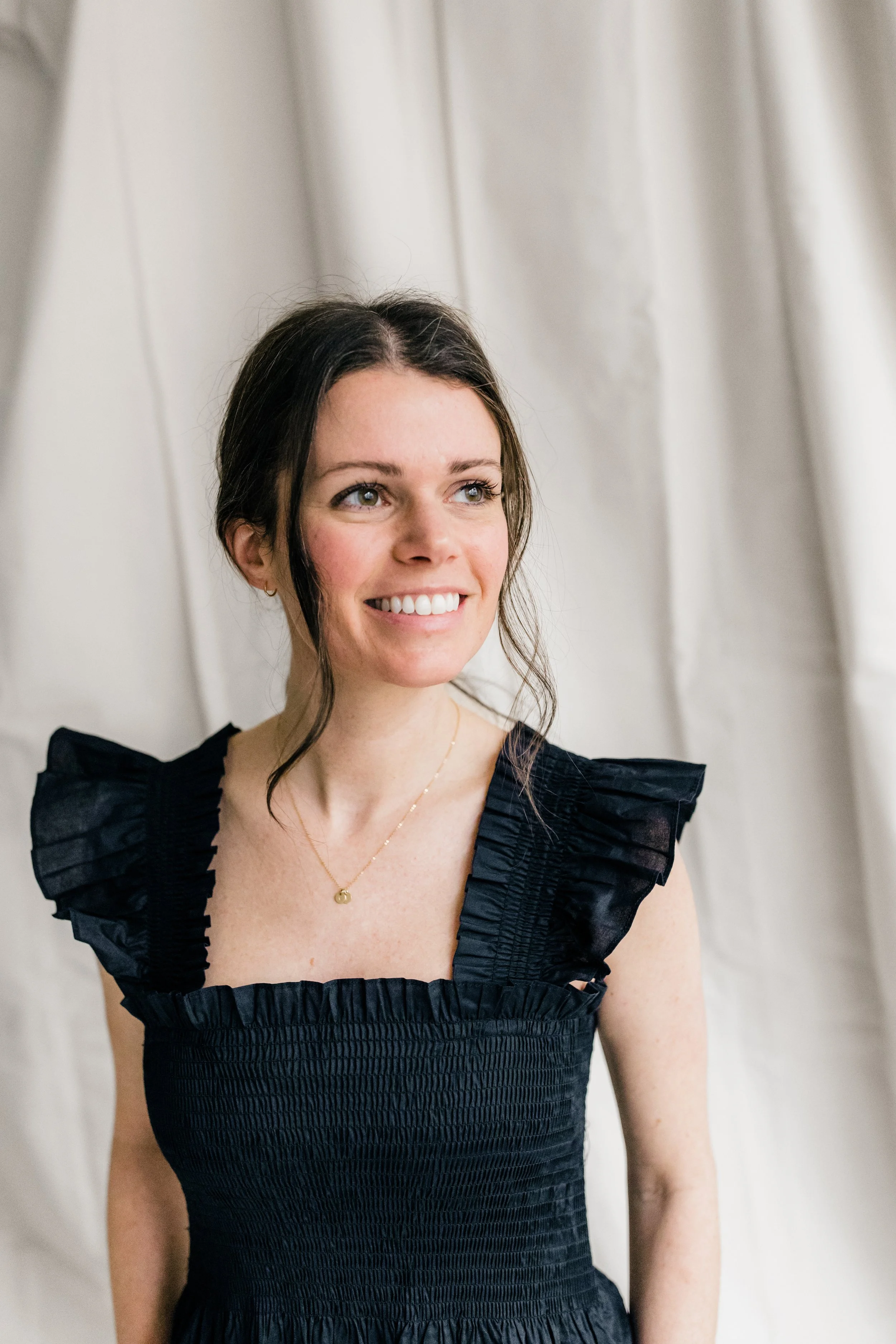 brunette girl smiling in black dress
