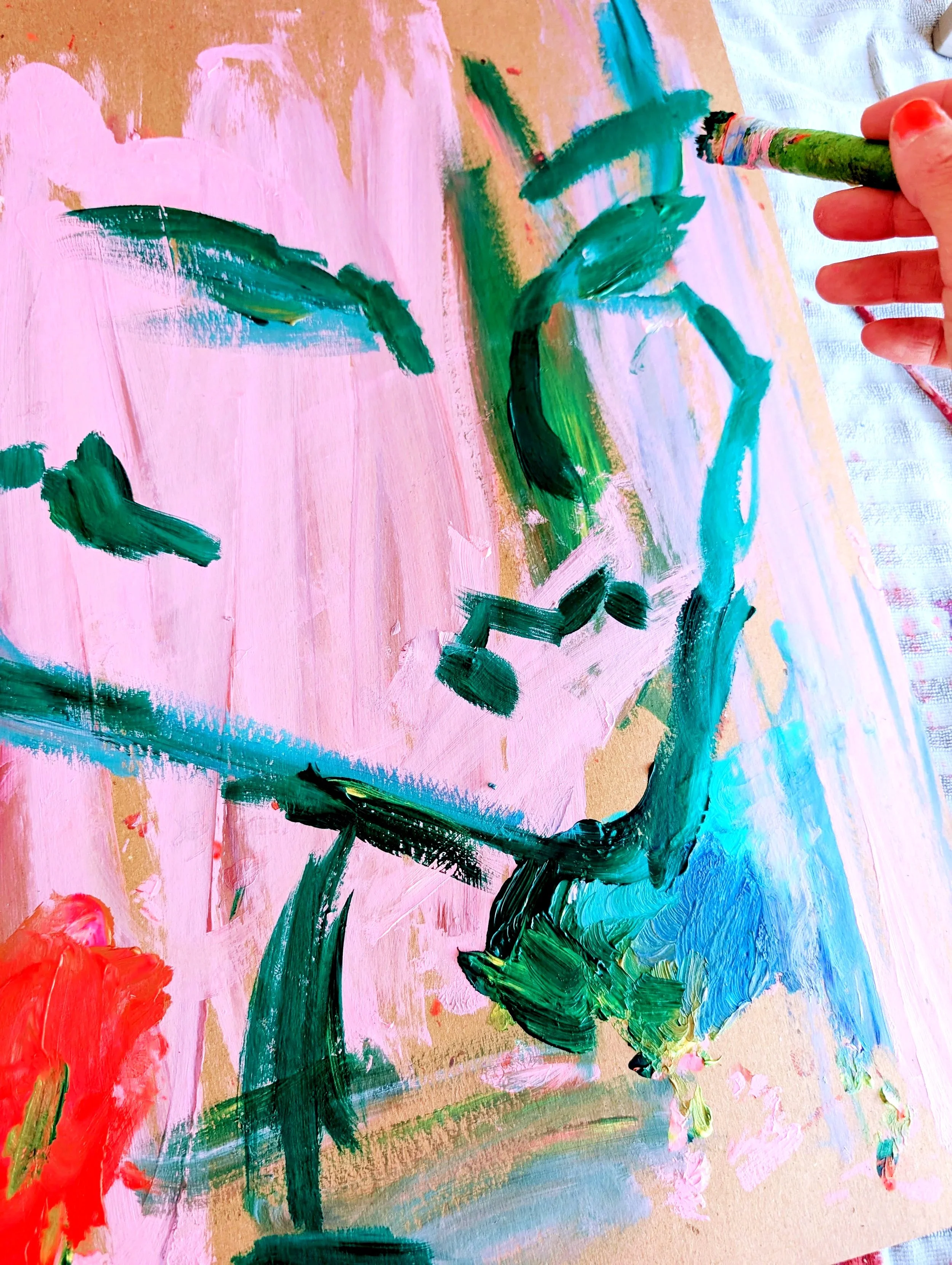Child's vibrant, abstract watercolor painting with prominent pink background, green strokes resembling a plant or tree, and accents of red, blue, and yellow on textured paper.