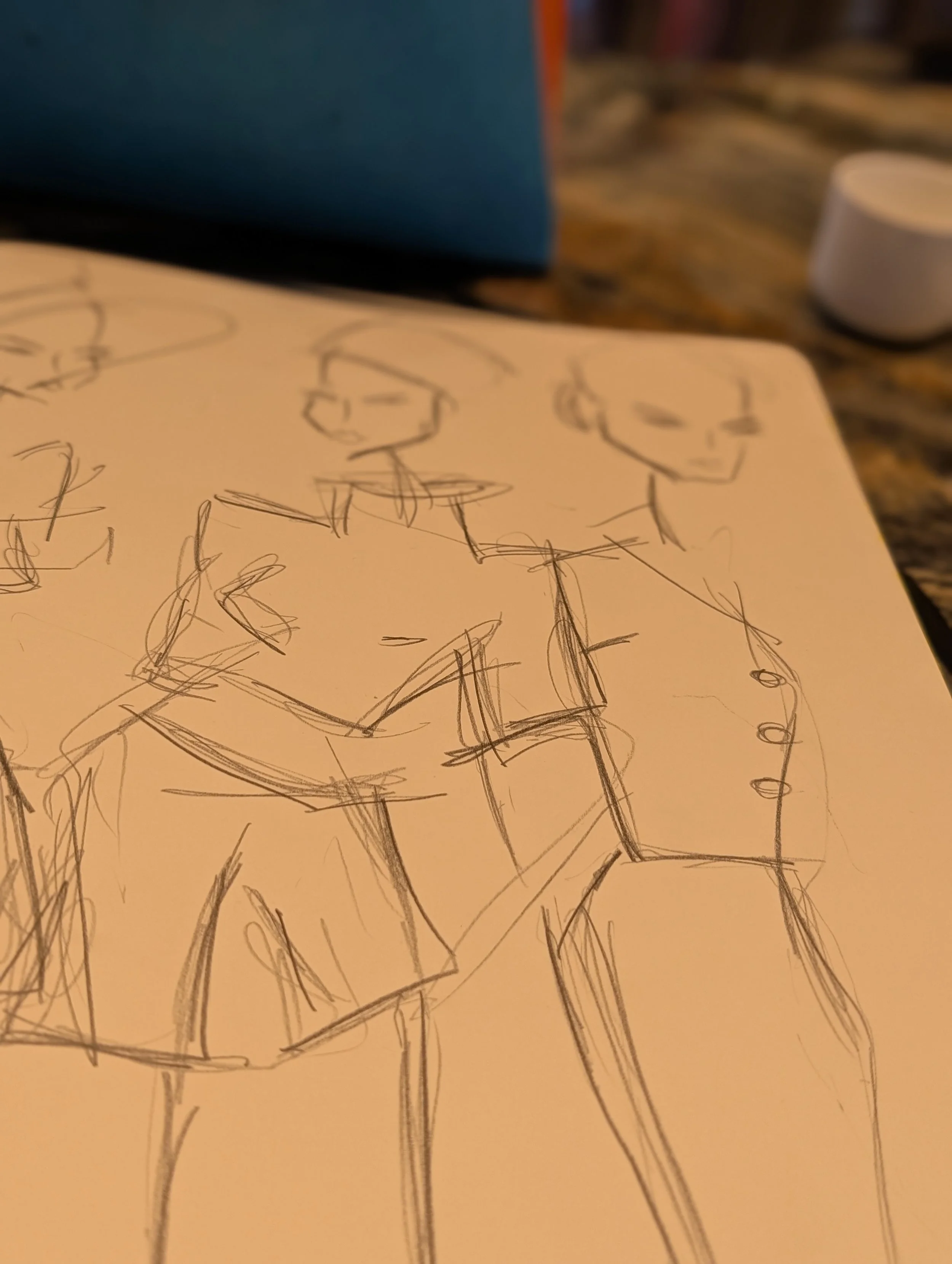 A sketch of two people on a piece of paper, with some objects and drawings in the background.