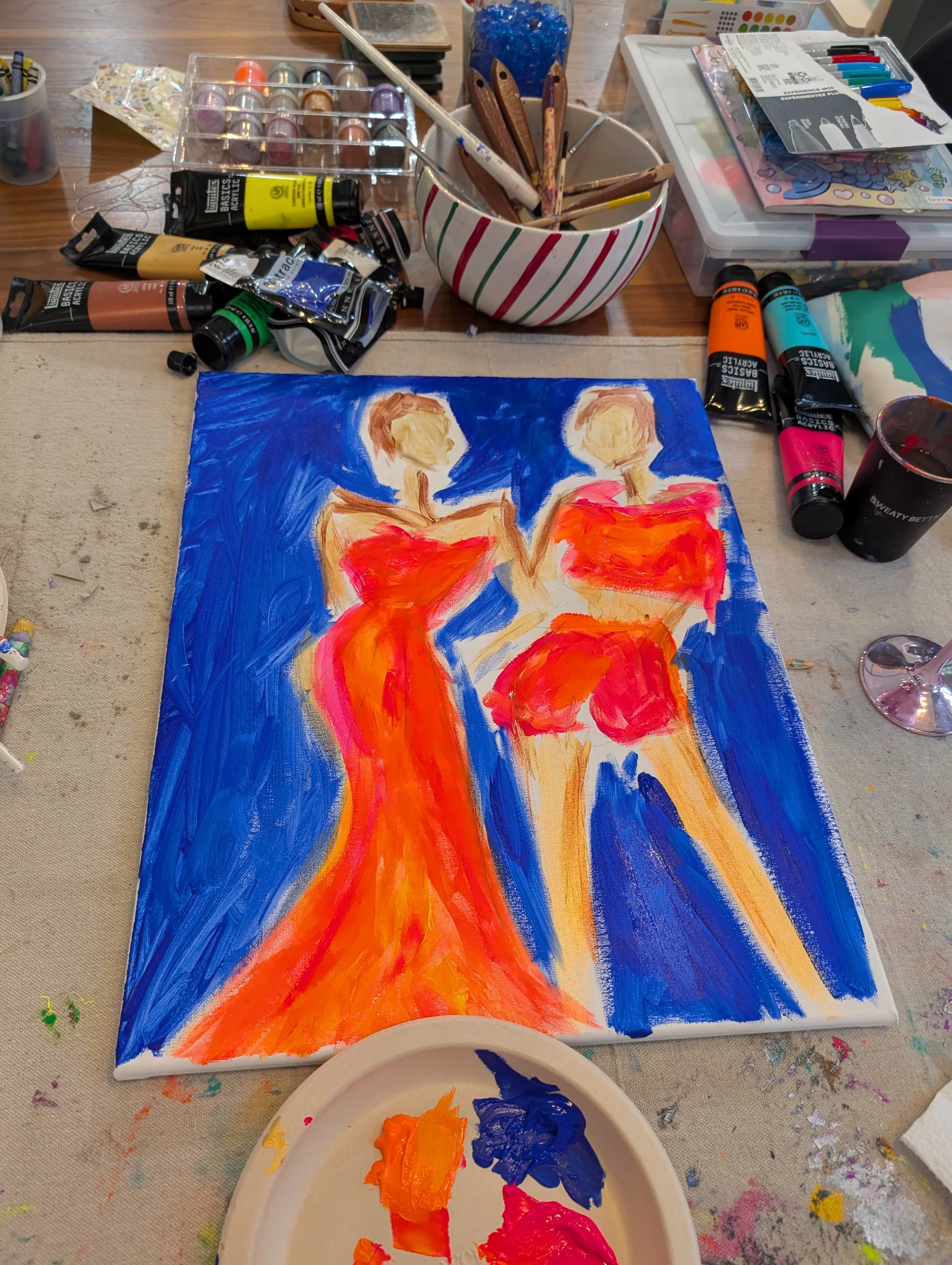 Abstract painting of two women in red dresses with a blue background, created with bright acrylic paints.