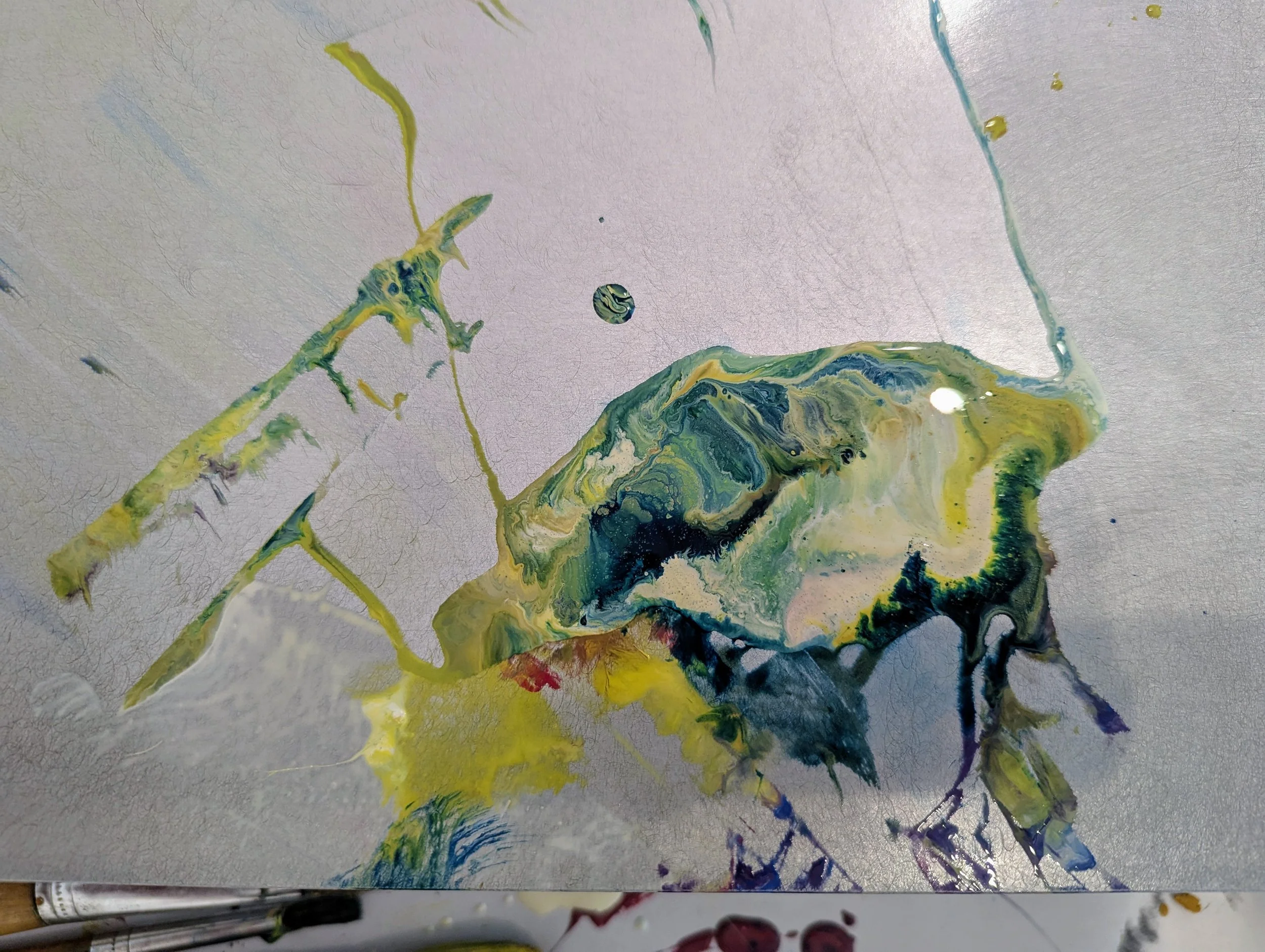 Abstract painting with swirling green, yellow, blue, and black colors on textured paper surface.