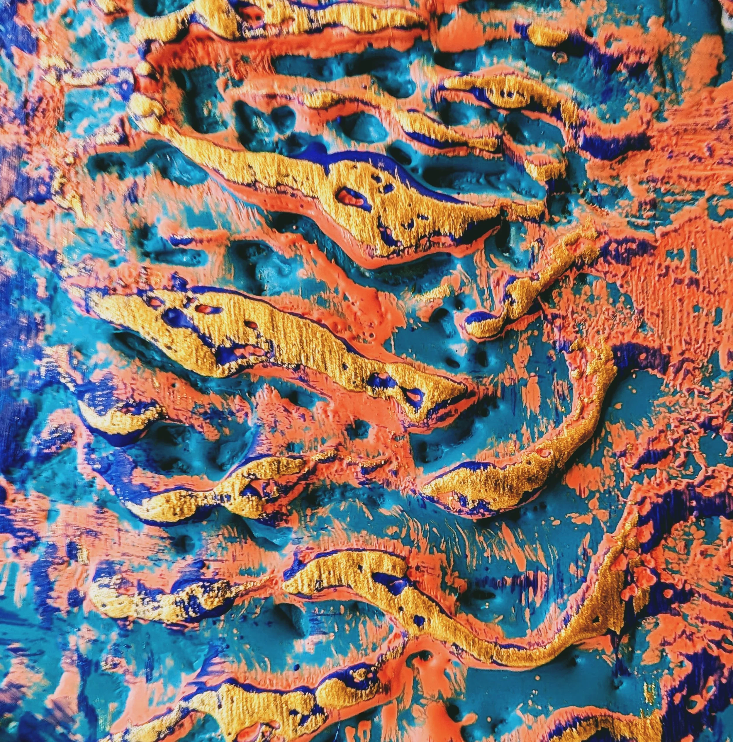 Abstract artwork with vibrant swirling patterns of orange, blue, pink, and gold colors.