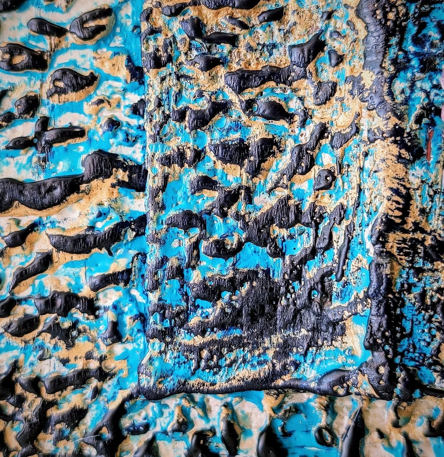 Close-up of a textured painting with black, blue, and beige colors forming an abstract pattern with layered, 3D-like effects.