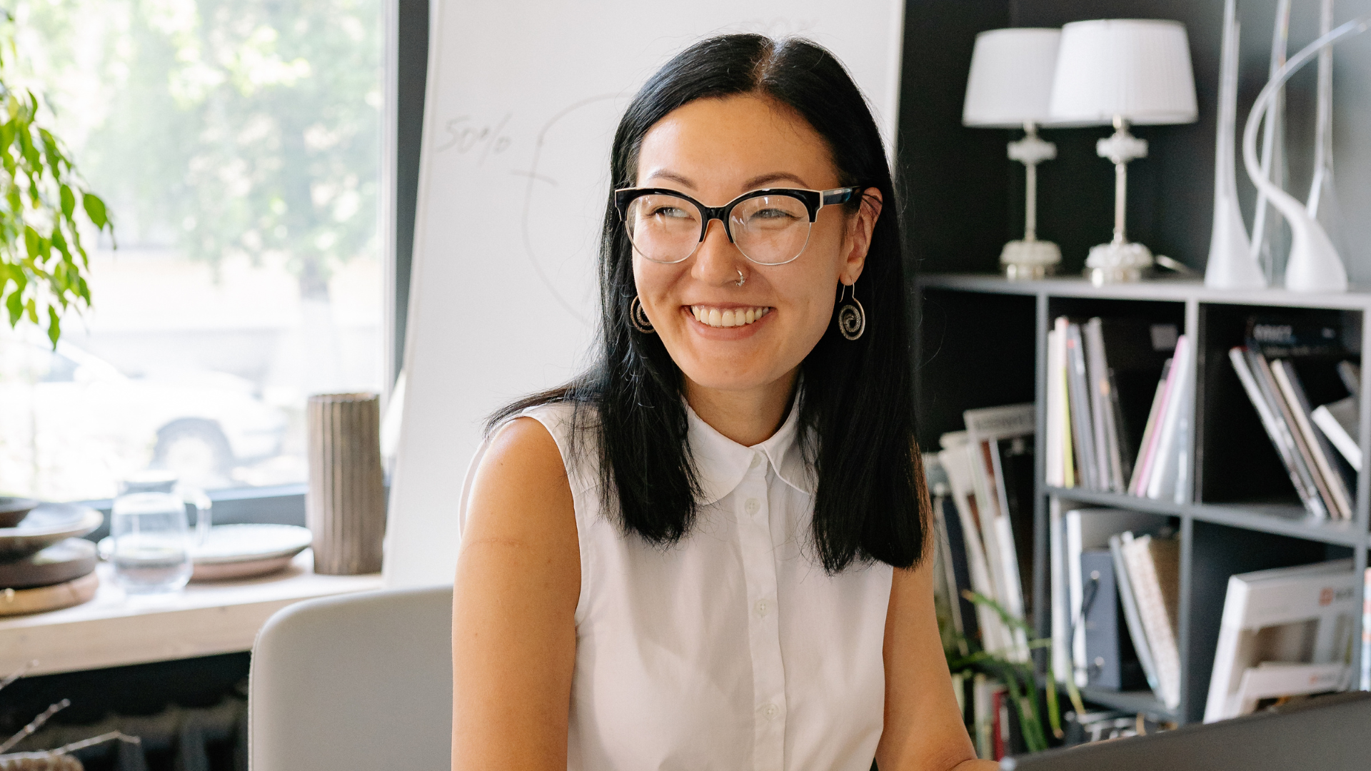 A woman smiling while working at a desk in a modern office