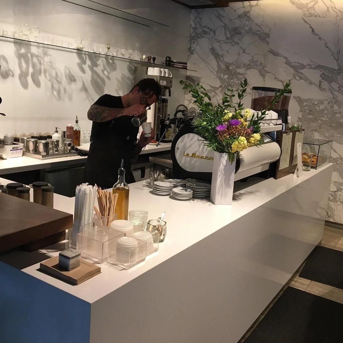 picture of barista pouring coffee in little owl coffee shop denver