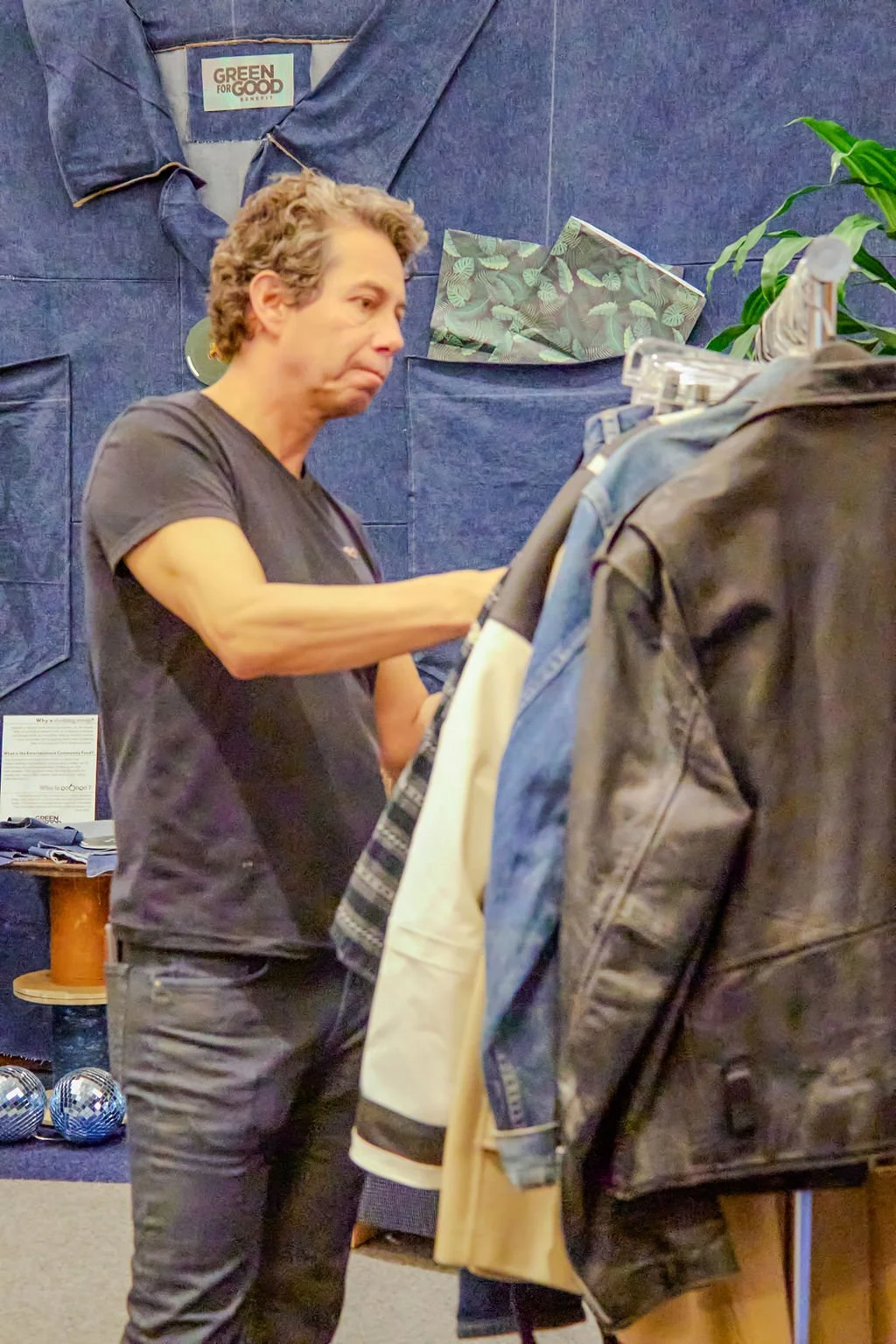 Man looks at racks of clothing at Roboro's Green For Good Benefit in Beverly Hills