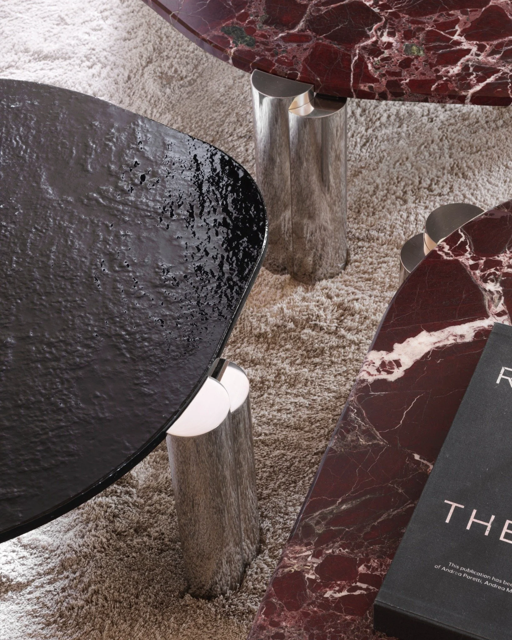 Maylis, design Christophe Delcourt, interpreta il tavolino come un sistema di volumi e livelli. 
Il piano esagonale, articolato tra superfici lisce e finiture a specchio, dialoga con basamenti in alluminio a diverse altezze, creando una geometria con