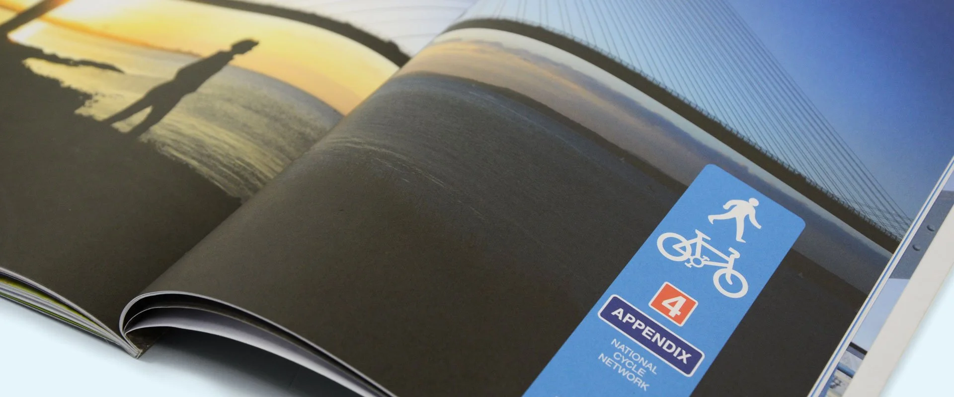 A photo showing an open page of the Paths for Everyone report showing a divider with a view of someone walking the path overlooking the Severn Bridge