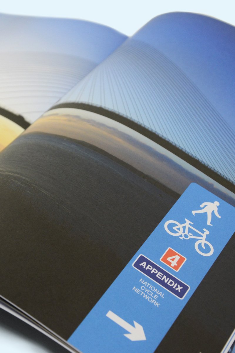 A photo showing an open page of the Paths for Everyone report showing a divider with a view of someone walking the path overlooking the Severn Bridge