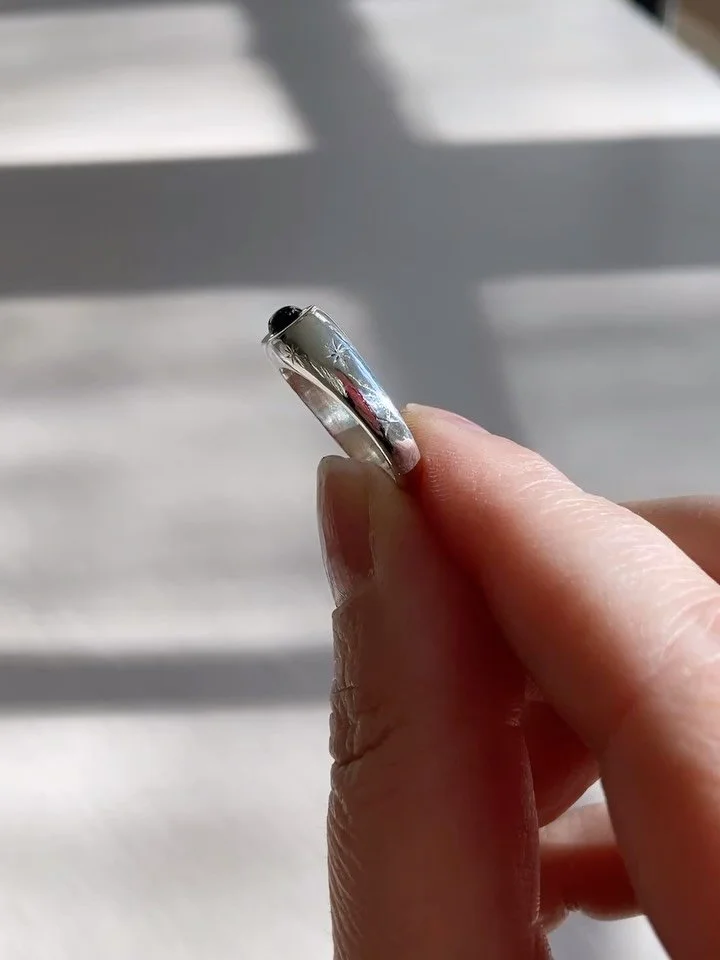 Carved by hand from wax, slowly and with intention, then brought into sparkling silver.
A ring that has weight to it but feels ethereal, almost elvish. Grounding, solid, tactile. 
Fine star engravings catch the light quietly, and the indigo-petrol gr