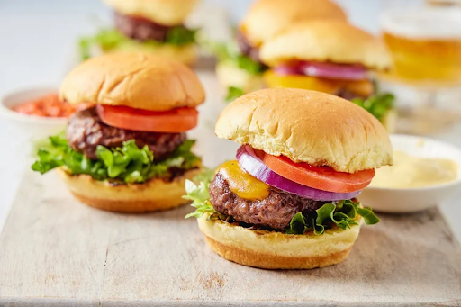 Interactive cooking class in Nantucket, MA featuring gourmet cheeseburgers with fresh toppings on brioche buns.