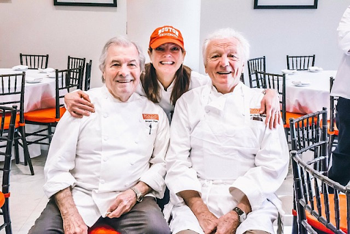 Chefs hosting an interactive cooking class at home in Nantucket, MA with guests in a welcoming culinary setting.