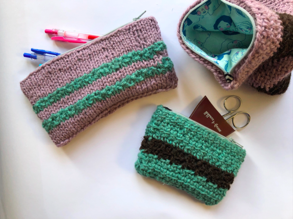 Finished knitted and crocheted pouches with fabric lining and zippers with pens and scissors