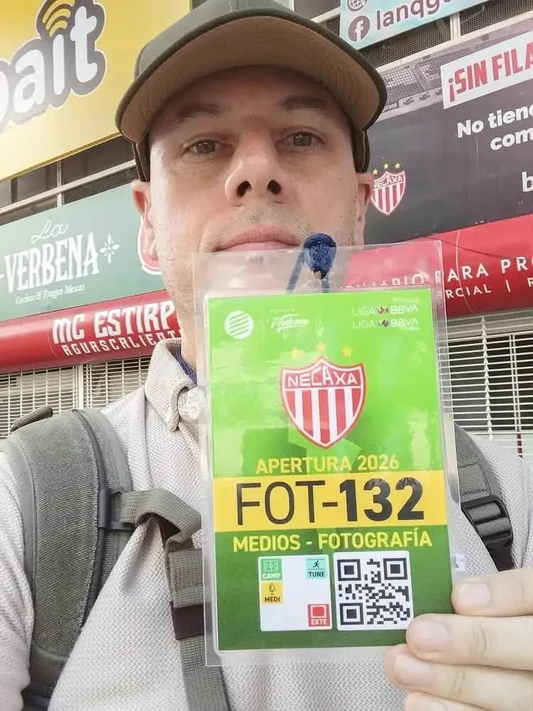 Professional photographer Alex Coghe in Aguascalientes, Mexico, holding a Liga MX Necaxa media pass while working on a football reportage assignment.