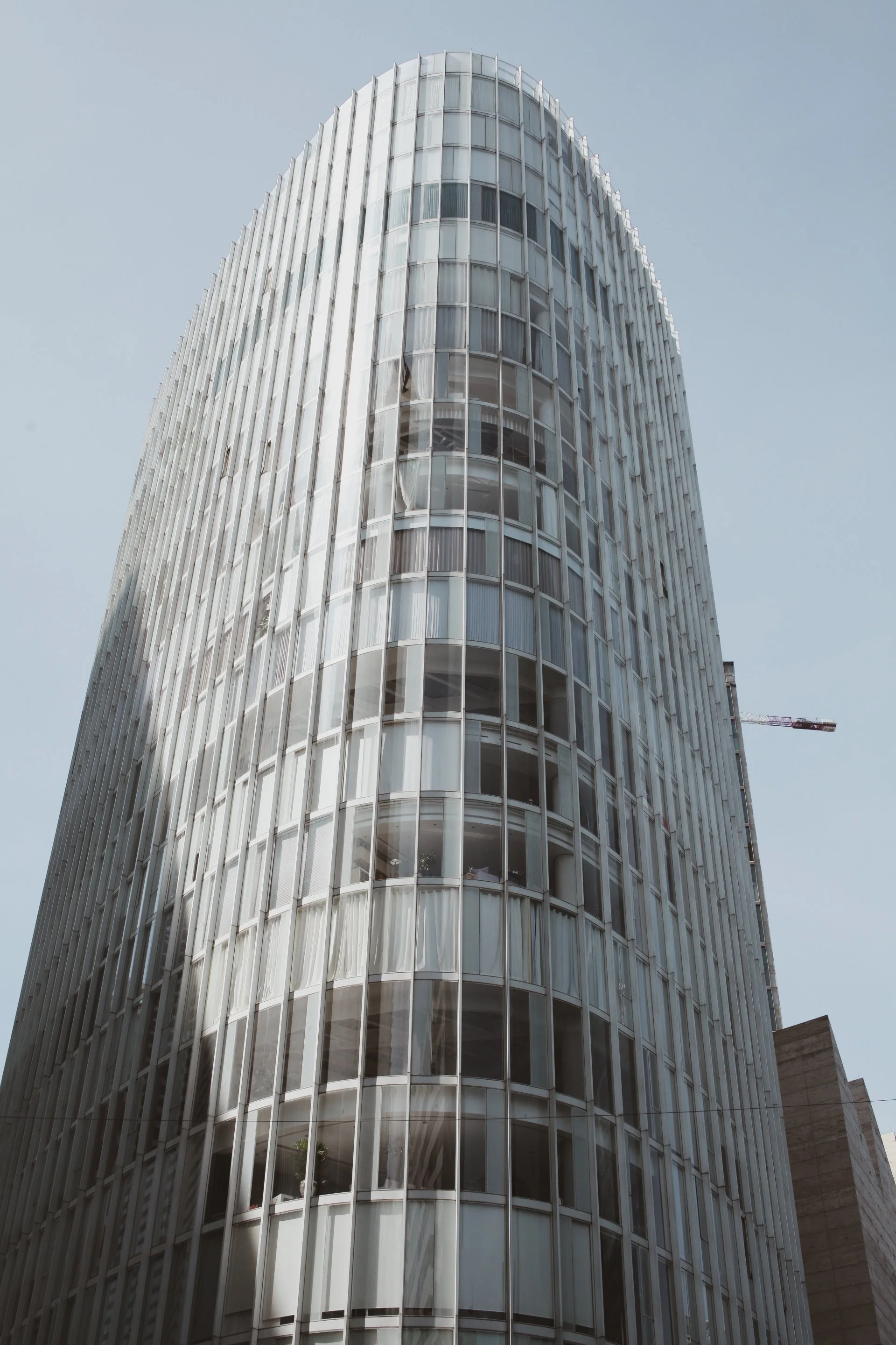 A tall modern building with rounded glass windows and vertical white panels, under a clear blue sky.”}}`}s most iconic buildings? Please specify the building's name or location. If you don't know, just say so.___)delivery requested.  It might be he