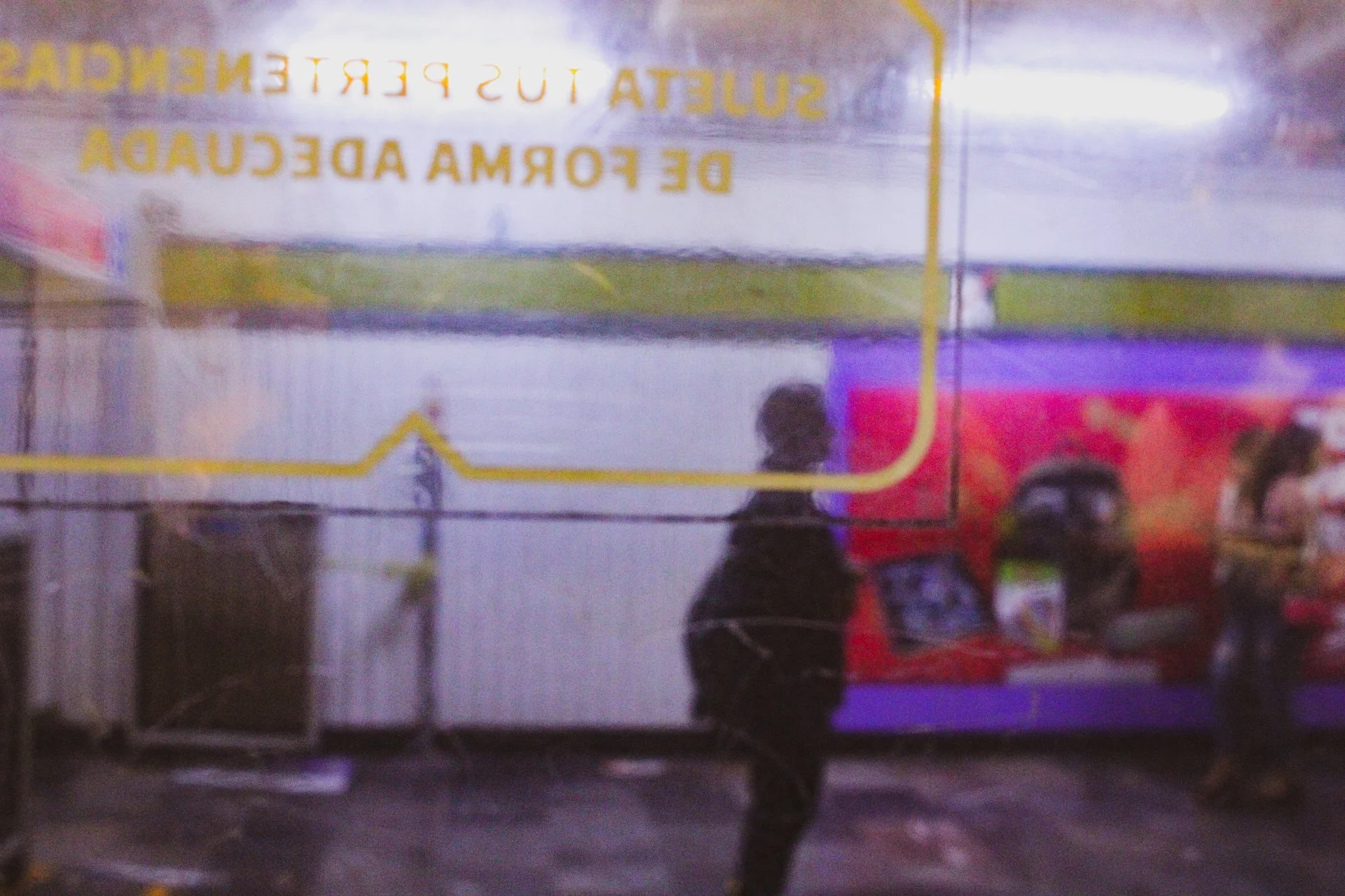 A woman silhouette standing beside a metro  station stop in Mexico City.