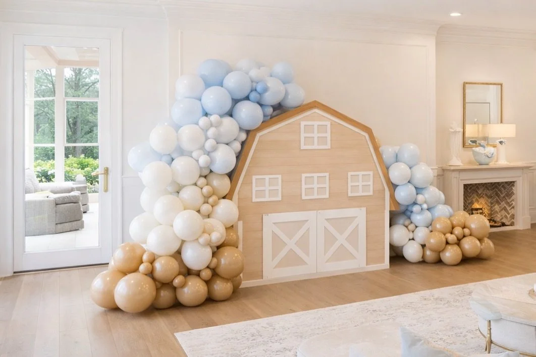 Soft blues, warm neutrals, and the sweetest little barn moment 🤍

We transformed this space into a dreamy, elevated farm-inspired setup featuring layered baby blue, white, and champagne balloons &mdash; anchored around a custom barn backdrop that ma