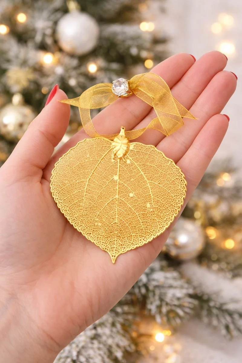 gold ornament in womans hand.png