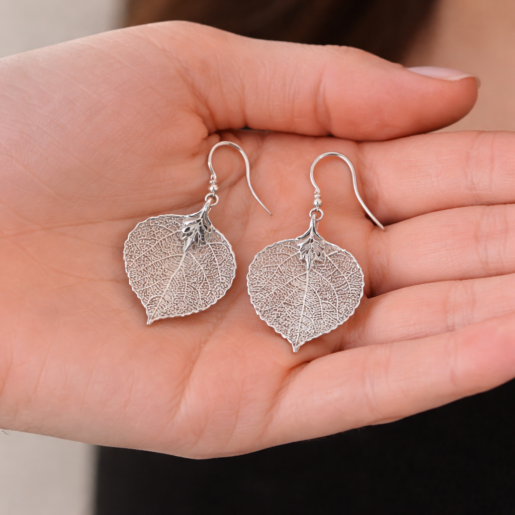 2 silver earrings in hand.png