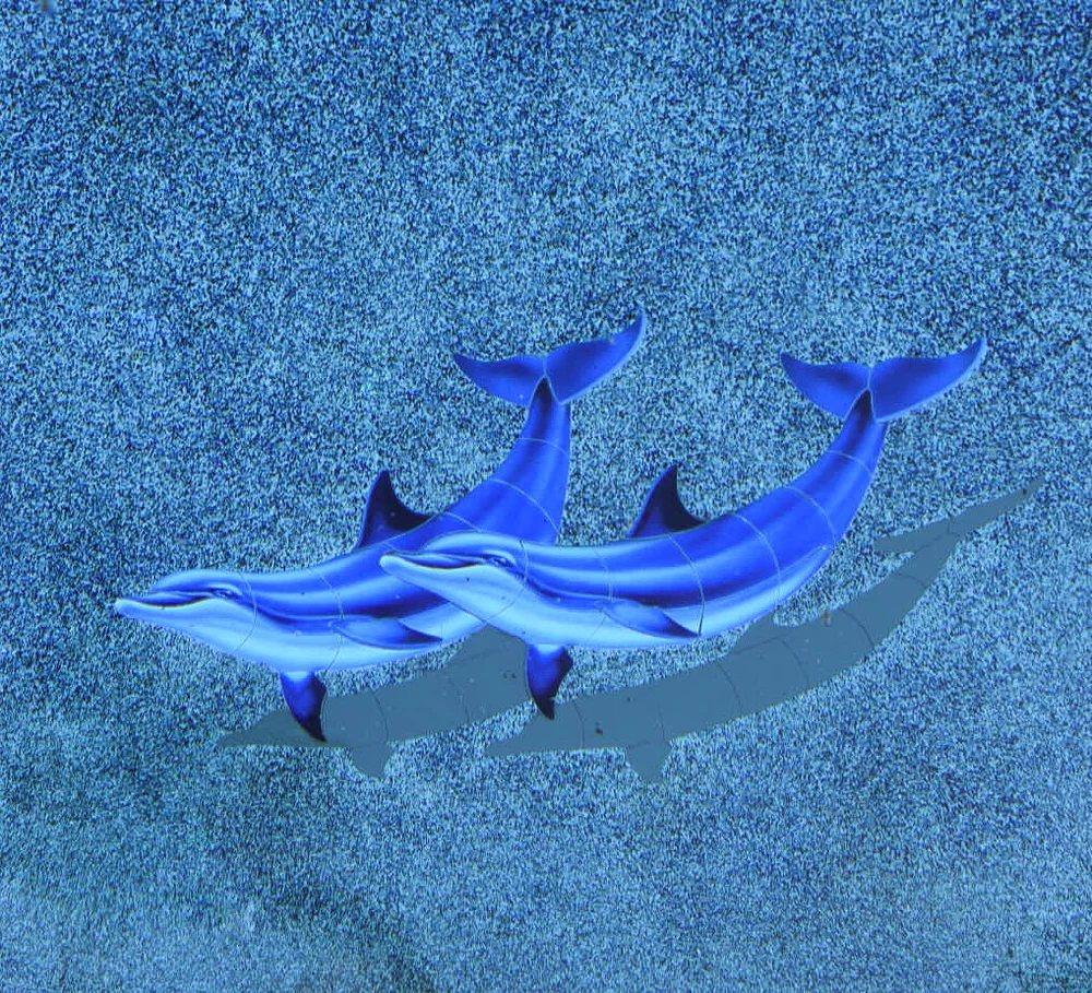 Two blue dolphin designs on a textured blue pool floor.