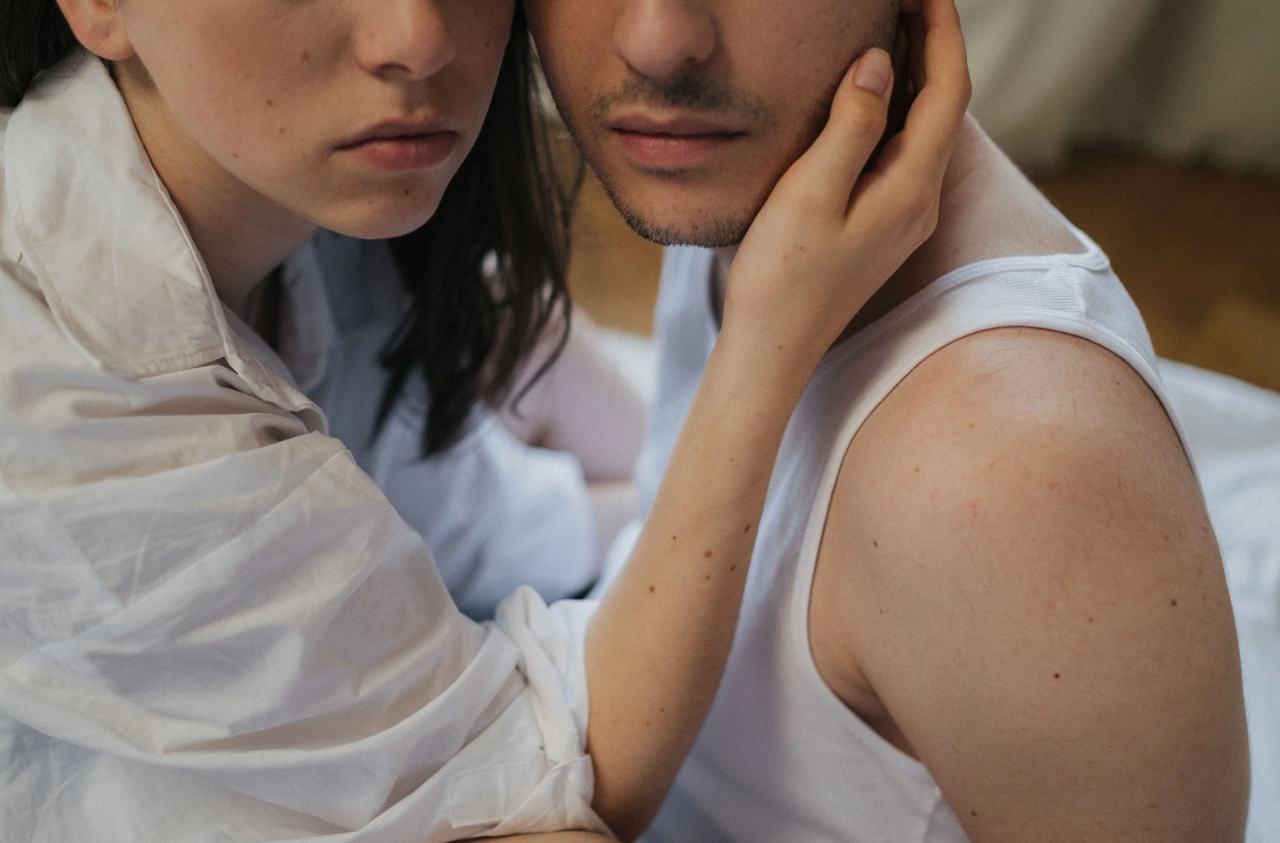 Couple sitting closely together during a difficult moment, reflecting the emotional strain that can bring partners to counselling.